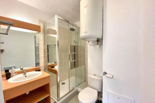 une salle de bain avec un lavabo, des toilettes et une douche dans l'établissement Logement en plein coeur de Cabourg, à Cabourg