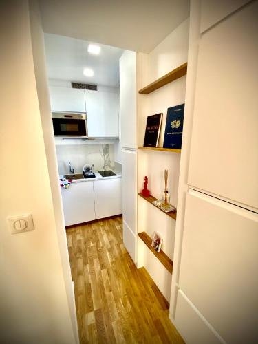 Elle comprend une petite cuisine avec des placards blancs et du parquet. dans l'établissement Suite Letizia, à Ajaccio
