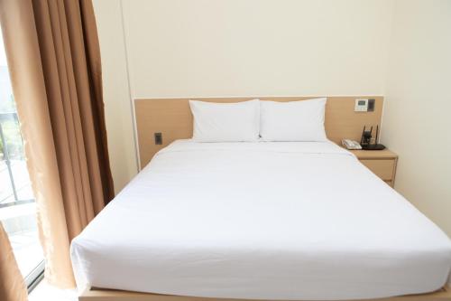 a white bed in a room with a window at SUNRISE Hotel HA TIEN in Ha Tien