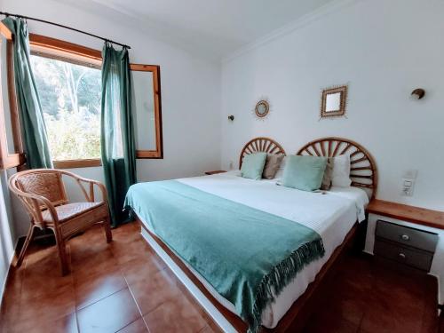 1 dormitorio con 1 cama, 1 silla y 1 ventana en Marmirada, en Sant Lluis