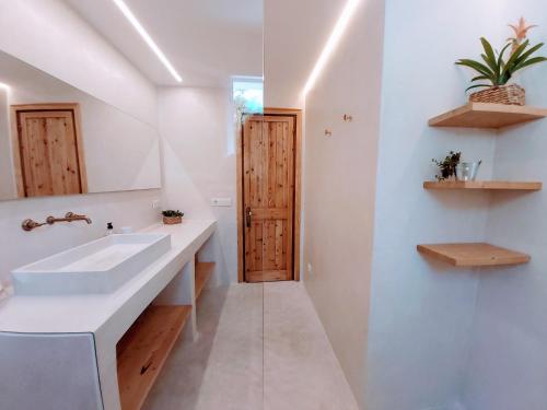 baño con lavabo y puerta de madera en Marmirada, en Sant Lluis