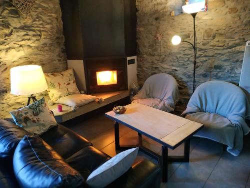 a living room with a couch and a table and chairs at la grange avec spa in Saint-Aventin