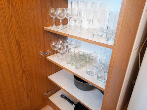 a bunch of glasses on shelves in a cabinet at Mátra Wellness Vendégház in Parádsasvár