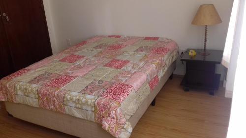 a bed with a quilt on it in a bedroom at Ótima localização in Águas de Lindóia