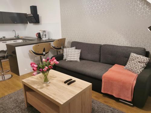 a living room with a couch and a coffee table at APT Nadmorskie - Feniks in Kołobrzeg