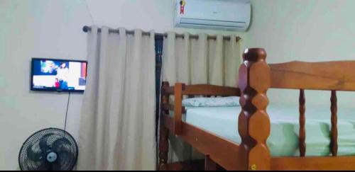 1 dormitorio con litera con cortinas y ventilador en Loft 01-Apês do Peró -Até 4 hóspedes, en Cabo Frío