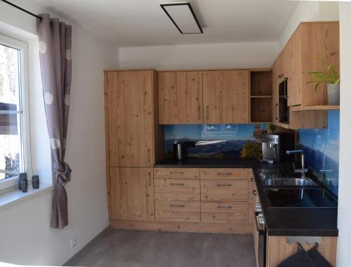 a kitchen with wooden cabinets and a sink at Alpenvereinshaus Pruggern in Pruggern