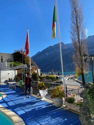 a person walking down a walkway with two flags at Heidi - Direct lake view in Brienz