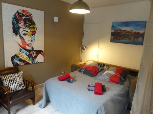 1 dormitorio con 1 cama con una pintura en la pared en Chez Jean - Newly renovated air-conditioned flat at the foot of the ramparts, 4 people, en Carcassonne