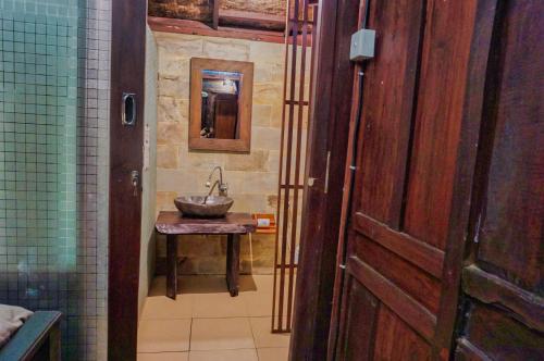 a bathroom with a sink and a mirror at The Wisma Pulau Merah in Pasanggaran