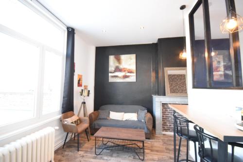 un salon avec un canapé et une chaise dans l'établissement leRelaisdOdile11 - BEL APPART CHIC INDUST - HYPERCENTRE - TRAM, à Valenciennes