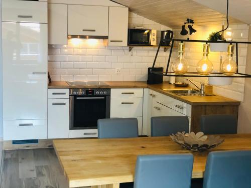 una cucina con armadi bianchi e tavolo in legno di S&P Mountain View Apartment 2 a Wilderswil