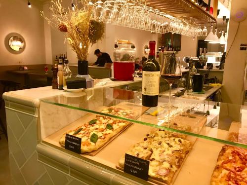 a display case in a restaurant with pizzas and wine at Hotel Alpina Luzern in Luzern
