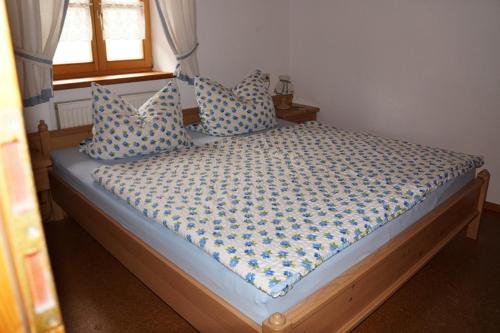 a bed with blue and white pillows in a bedroom at Sulzenhof in Ruhpolding