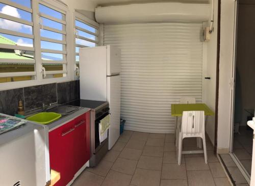 a kitchen with a white refrigerator and a table at Tropic Arth Paradise in Port-Louis