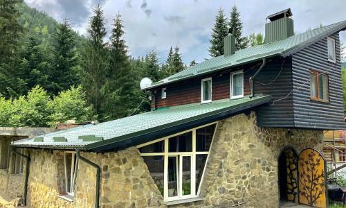 a house with a green roof on top of it at Hotel Chateau in Bukovel