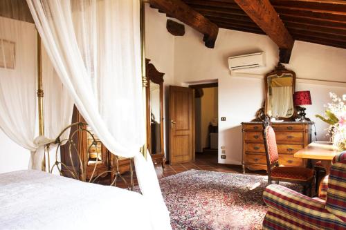 a bedroom with a bed and a dresser and a mirror at Villa Il Fedino in San Casciano in Val di Pesa