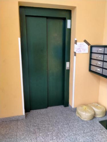 a green door in the corner of a room at AiRPORT ALEXANDER in Genoa