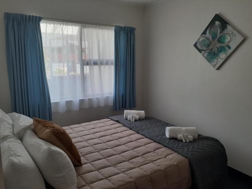 a bedroom with a large bed with a window at Golden Bay Motel in Takaka