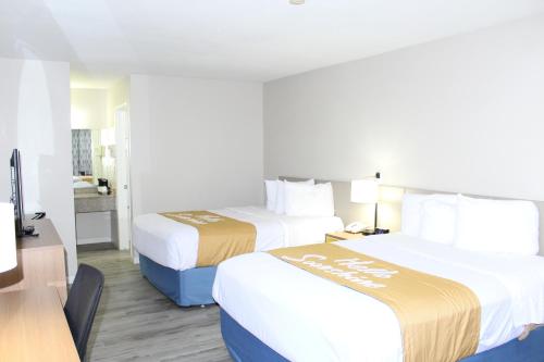 a hotel room with two beds and a desk at Days Inn by Wyndham Willcox in Willcox