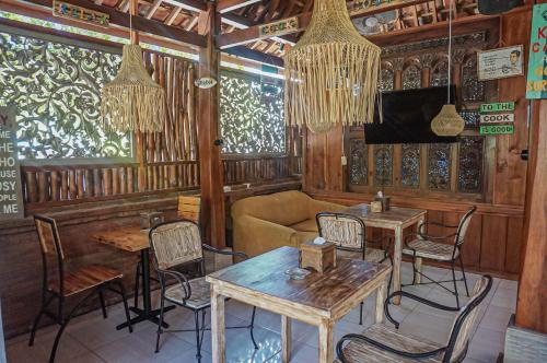 un ristorante con tavoli, sedie e un divano di Wisma Pulau Merah a Pasanggaran