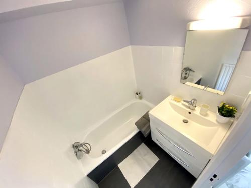 ein Badezimmer mit einer weißen Badewanne und einem Waschbecken in der Unterkunft Studio with terrace and sea view, 10 min to the beach in Nizza