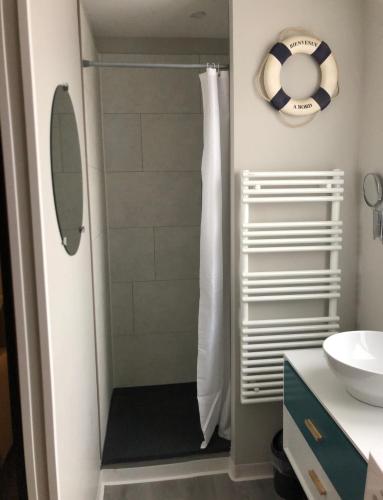 La salle de bains est pourvue d'une douche avec un ballon de football sur le mur. dans l'établissement LE DRAKKAR - 1 chambre - 4 personnes - Proximité de la plage, à Saint Martin de Brehal
