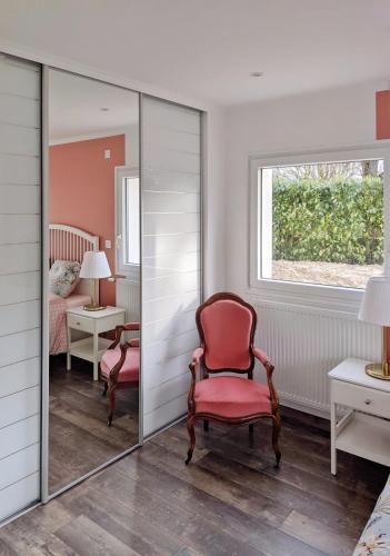 Cette chambre comprend un miroir, une chaise et un lit. dans l'établissement Maison Blanche en Côte de Nacre, à Mathieu