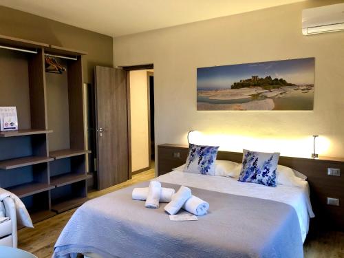 a bedroom with a bed with towels on it at International Rooms & Apartments in Sirmione