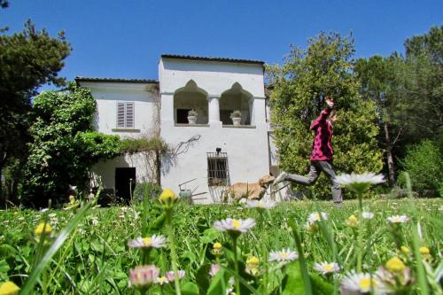 a man running in front of a house with a dog at Agriturismo "Borgo Madonna degli Angeli" - charming cottages in the gardens ! in Tocco da Casauria