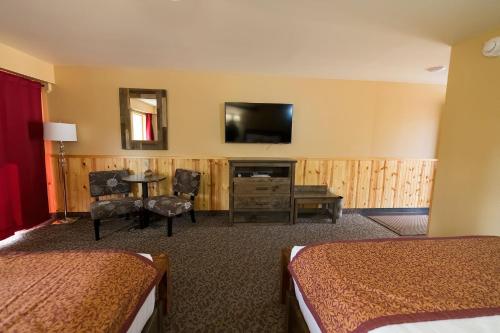 a hotel room with two beds and a flat screen tv at McKinley Creekside Cabins in McKinley Park