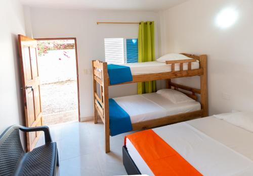 Zimmer mit 2 Etagenbetten und einem Fenster in der Unterkunft White Taganga in Taganga