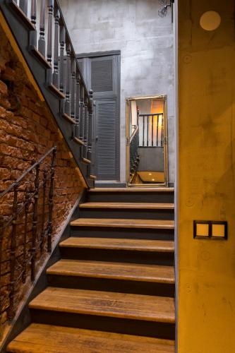 a staircase with a mirror and a brick wall at Apartament Podcienie z tarasem Bielsko-Biała Old Town in Bielsko-Biala