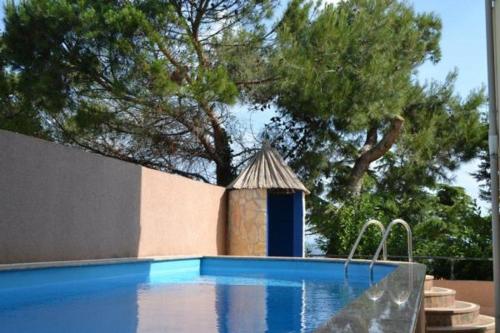 a swimming pool with a small building next to a tree at Villa del Golfo in Savudrija
