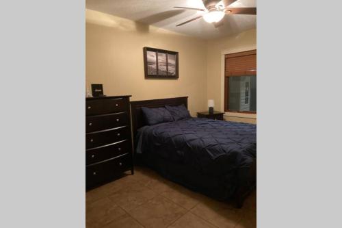 a bedroom with a bed and a dresser and a ceiling fan at Dream Valley Wellness Retreat in Lake Country