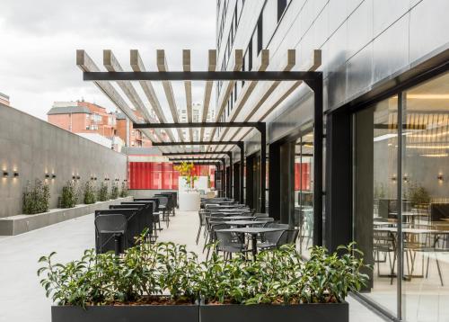a restaurant with tables and chairs on a building at Hotel Ilunion San Mamés in Bilbao