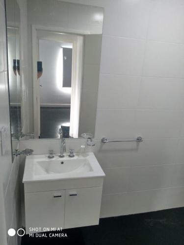 a white bathroom with a sink and a shower at Vista Angular in Tandil