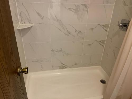 a bathroom with a shower with a white tub at Landmark Inn in Osawatomie