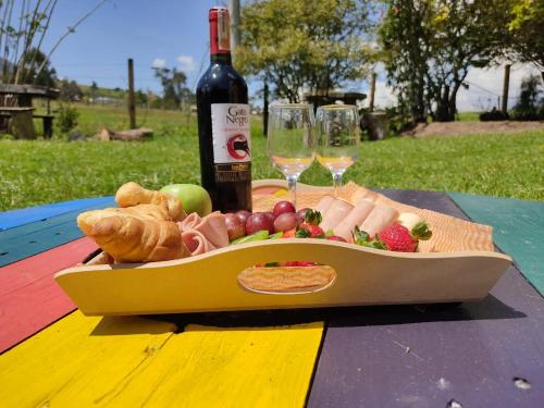 a plate of food and a bottle of wine on a table at Iwoka Ecoturismo in La Calera