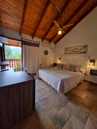 a bedroom with a large bed and a wooden ceiling at Posada Aitue in Villa General Belgrano