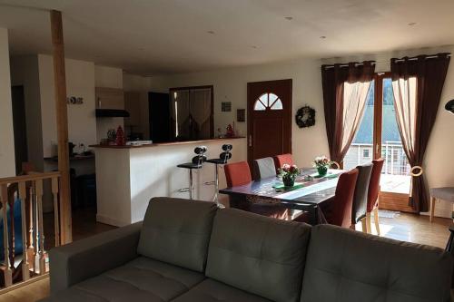 un salon avec un canapé et une table et une cuisine dans l'établissement Chalet Loulou, massif central, Le Mont-Dore, à Le Mont-Dore
