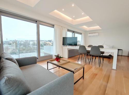a living room with a couch and a table with chairs at Verde Apartments in Athens