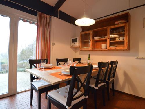 een eetkamer met een houten tafel en stoelen bij Holiday Home in Gemmenich with Forest Views in Ten Eiken