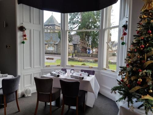 un comedor con un árbol de Navidad y una mesa en McInnes House Hotel, en Kingussie