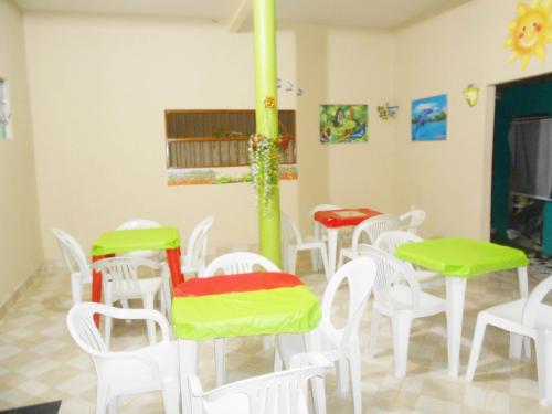 a group of tables and chairs in a room at Pousada Salmo 23 in Algodoal