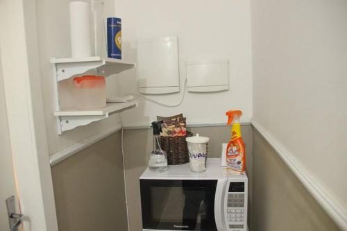 a small kitchen with a microwave on a counter at Casa Rebello - Pousada in Itajaí