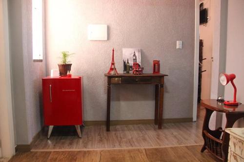 a room with a red refrigerator and a table at Casa Rebello - Pousada in Itajaí
