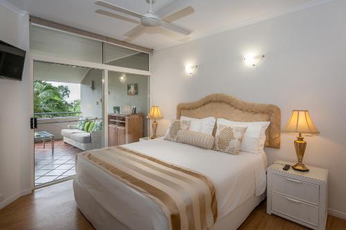 a bedroom with a large bed and a living room at Oasis at Palm Cove in Palm Cove
