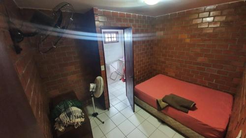 a small room with a red bed in a brick wall at Gravatá Country House in Gravatá