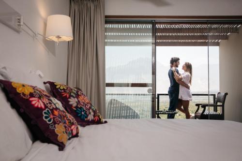 a bride and groom kissing in front of a window in a hotel room at Empedrada Ranch & Lodge - Hotel Asociado Casa Andina in Caral